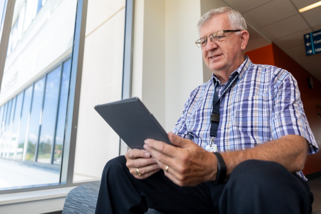 Gary Halyk, a Patient and Family Advisor, looking at an iPad